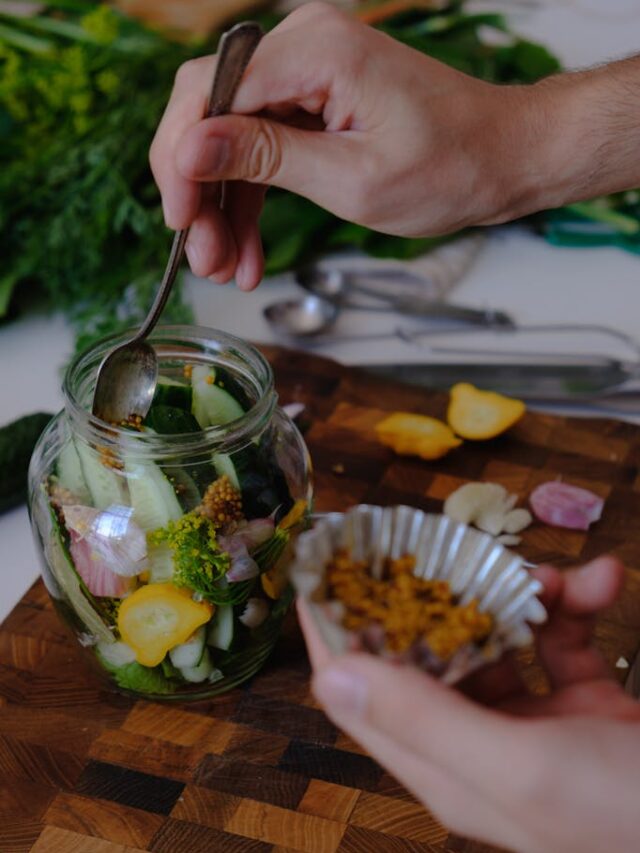 Person Putting Ingredients in a Glass Jar for Fermentation